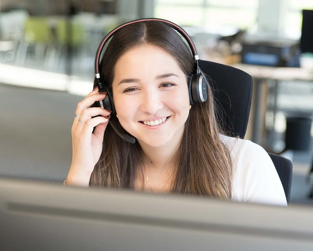 Mitarbeiterin des MPF-Kundenservice mit Headset am Arbeitsplatz